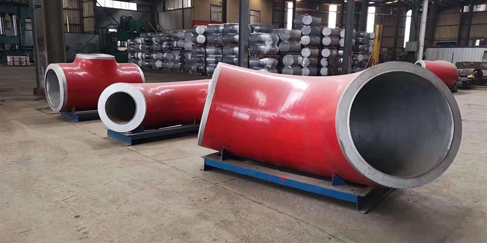 Large-bore P91 alloy steel elbows and tees in the factory, painted for shipment